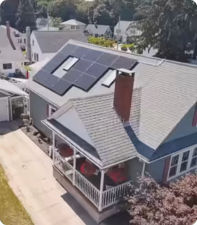 Aerial view of a house in Massachusetts with solar panels on the roof, showcasing renewable energy installation for potential income generation and energy savings.