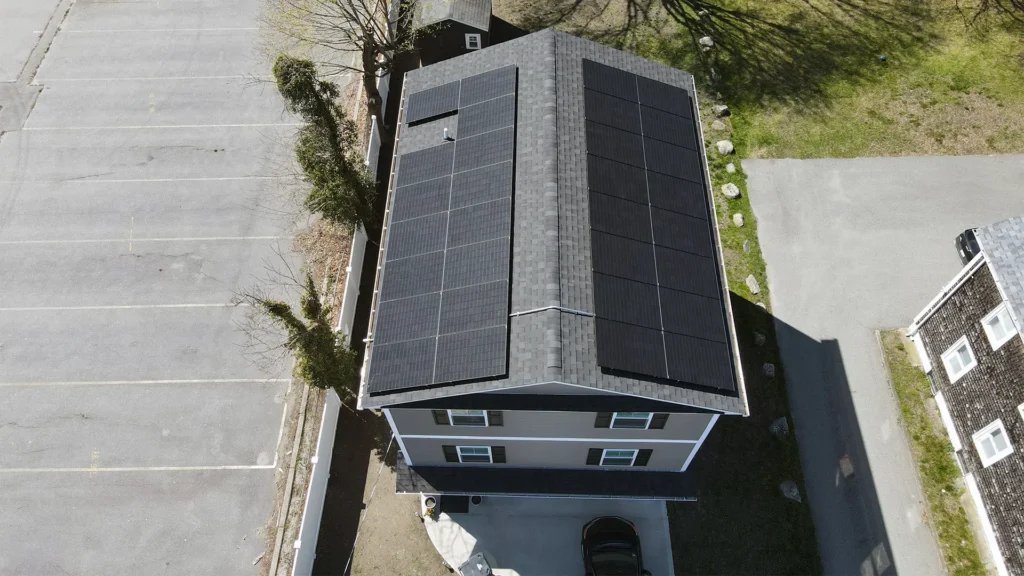 Aerial view of a residential home with solar panels installed on the roof, highlighting energy-efficient features relevant to home resale value in New England.