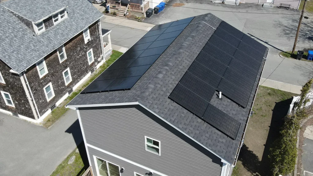 Aerial view of a home with solar panels on the roof, showcasing modern energy solutions contributing to home value in New England.